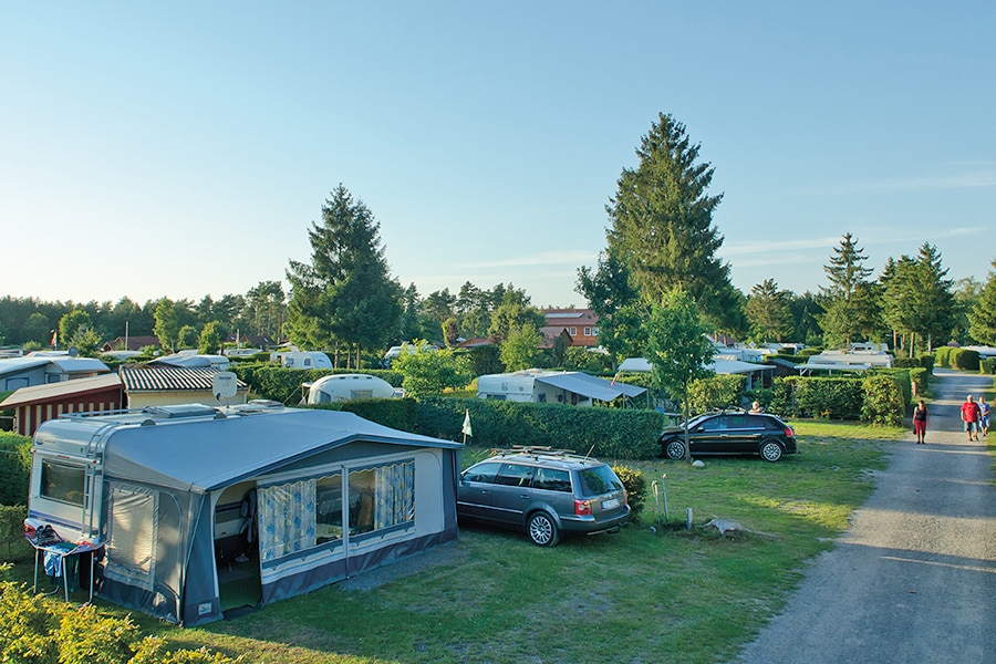 campers en caravans tussen heggen op afgebakende veldjes